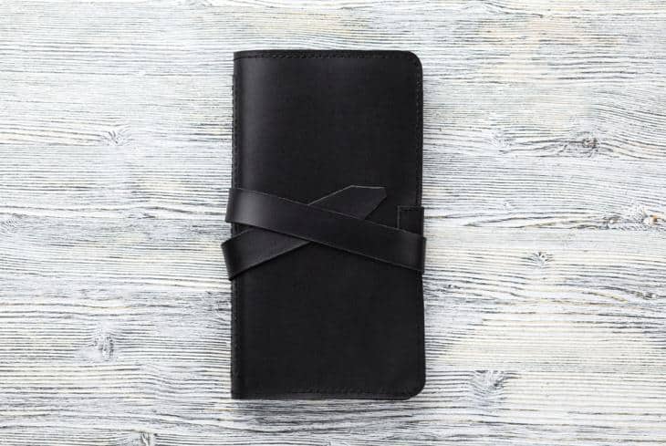 A black checkbook wallet with straps