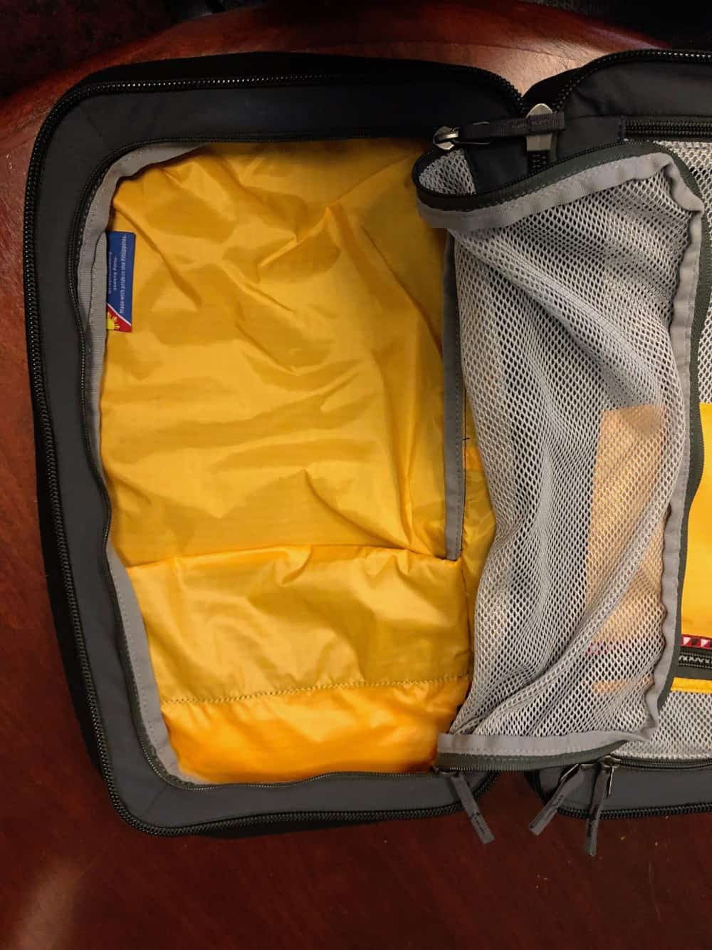 Left storage area with mesh covering unzipped on the Cotopaxi Nazca travel pack.